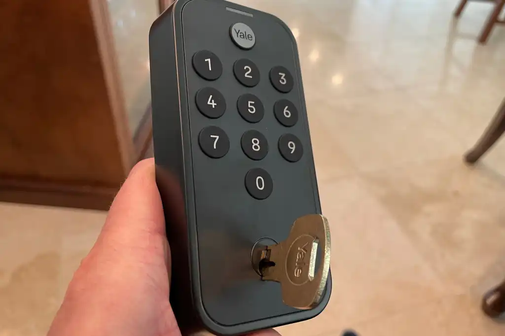 Hand entering code on Yale smart door lock keypad