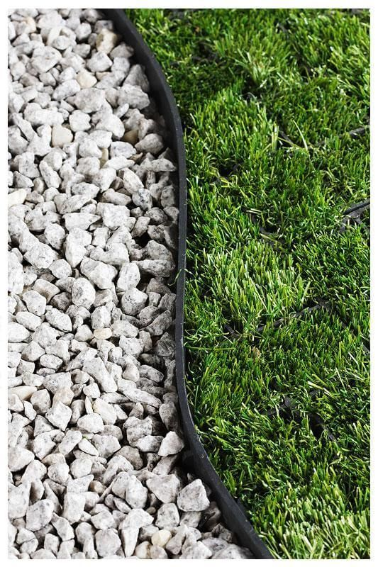 Garden edging separating gravel pathway from green lawn grass